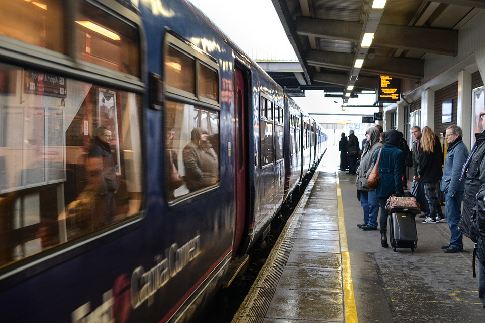 Les-CRIs.com : une illustration de l'utilisation du mot Plateforme : Plateforme de quai de gare, avec train arrivé à quai, et des personnes attendant pour monter dans le train.
